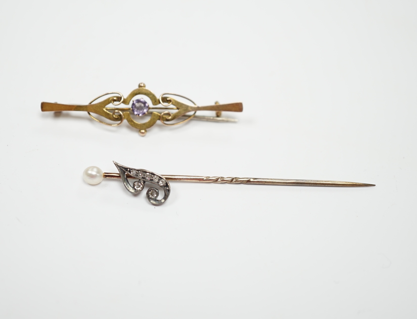 An early 20th century diamond chip and seed pearl set initial stick pin, 65mm and a 9ct and gem set brooch.